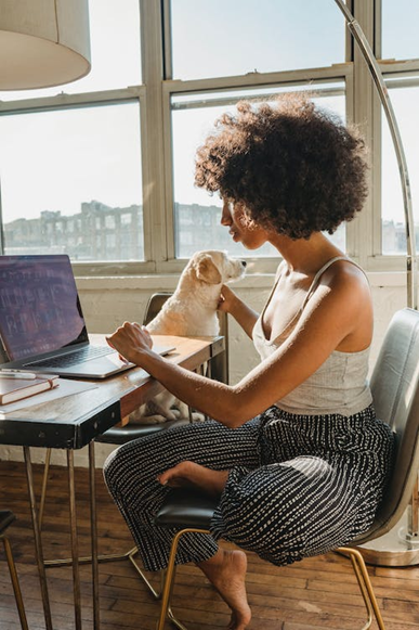 Lady working at desk with a dog for how to start a pooper scooper business page