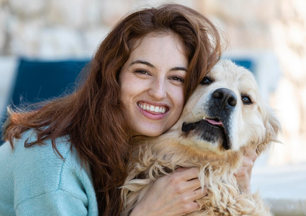 Woman petting a golden retriever dog