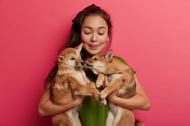 Lady holding two dogs in her arms looking content and happy.