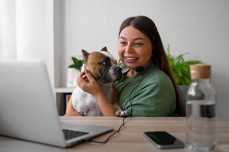 image lady using a laptop with a dog in her lap on starting a pooper scooper business web page